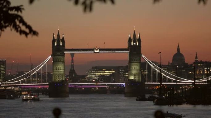 伦敦塔桥和圣保罗大教堂的圆顶在晚上从泰晤士河的河岸