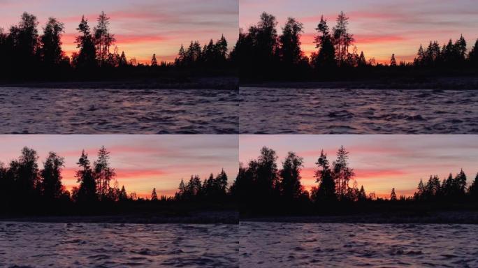 河边的夜景，岩石海岸的树木轮廓，日落色的天空背景