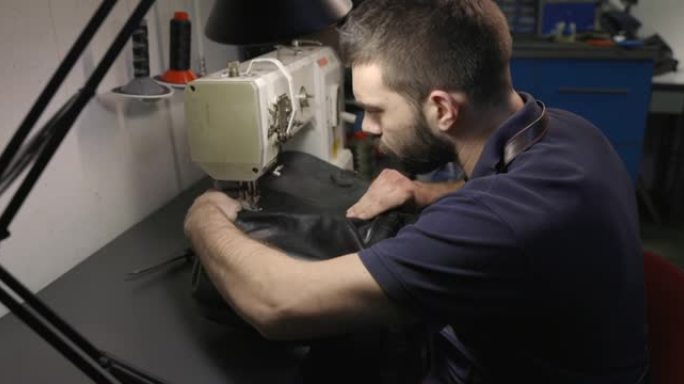 经营小企业的年轻人在缝纫机上修理皮革钱包