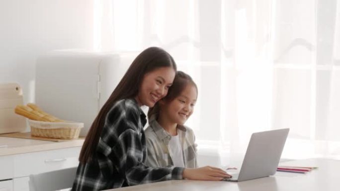 亚裔妈妈教女儿在家使用手提电脑