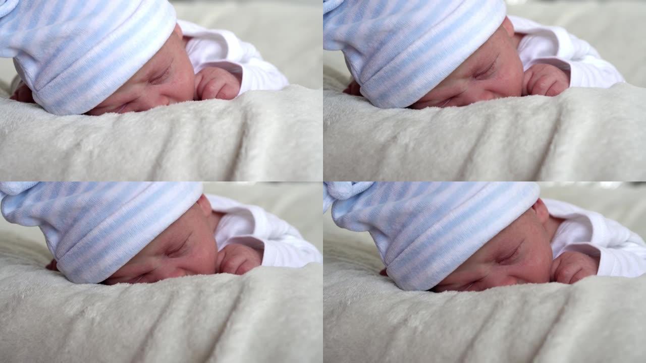 特写新生儿面部肖像早期甜蜜地睡在肚子米色白色背景上。孩子在帽子上生命的开始。婴儿，分娩，出生的最初时