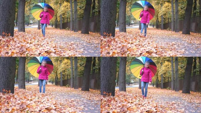 小女孩带着彩虹伞散步秋天秋天金色橙色枫叶在公园