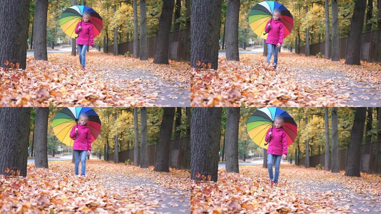 小女孩带着彩虹伞散步秋天秋天金色橙色枫叶在公园