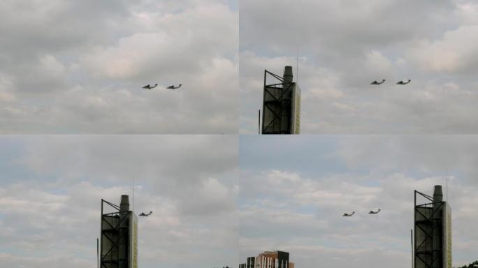 两架军机列队在城市上空高高地飞行。空军游行。