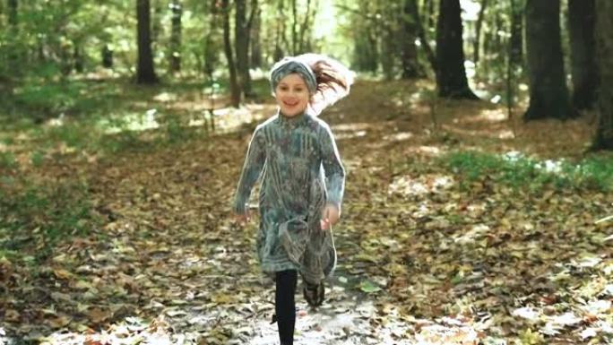 快乐的小孩，在公园森林里笑着玩着秋天的落叶。腿在秋天的多色枫叶上行走