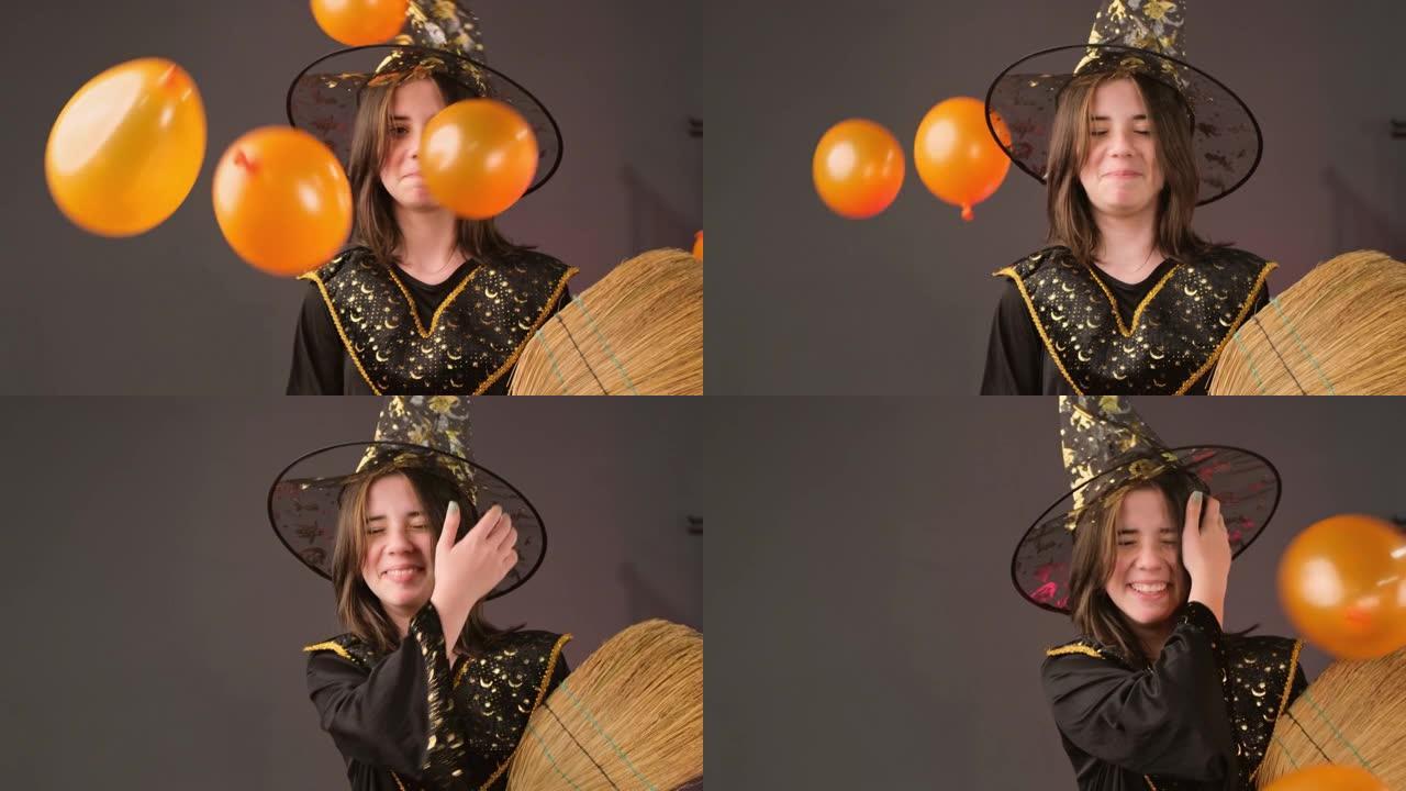 特写视频，一个魔术师女孩手里拿着扫帚，有人向她扔橙色气球，她在笑。