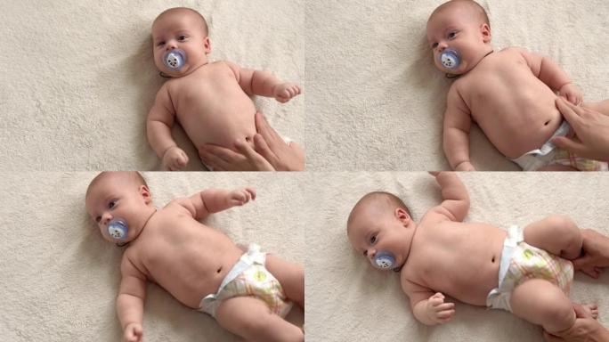 健康护肤，发展儿科学，婴儿近身妈妈双手给裸婴婴儿在手臂、腿部、手指上进行小儿按摩，在足部反射运动，在
