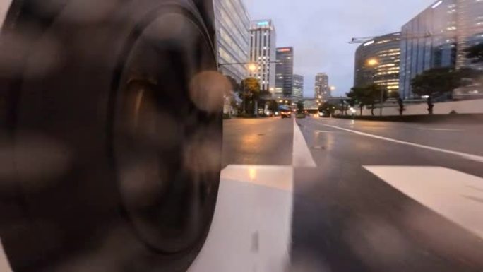 在雨夜开车穿过城市。汽车车轮的特写。在十字路口右转