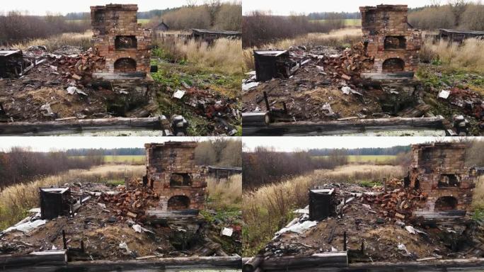 一栋烧毁的农村房屋，带有剩余的砖烤箱，鸟瞰图。