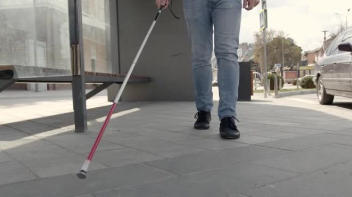 一个无法辨认的盲人独自走在城市里