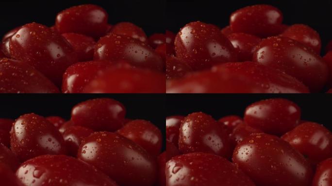鲜红色的西红柿上沾满了水滴。黑暗背景下农场的许多西红柿。用于制造番茄汁的蔬菜。