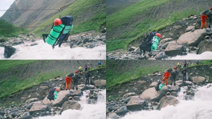 登山者将他们的装备运送过一条山河。