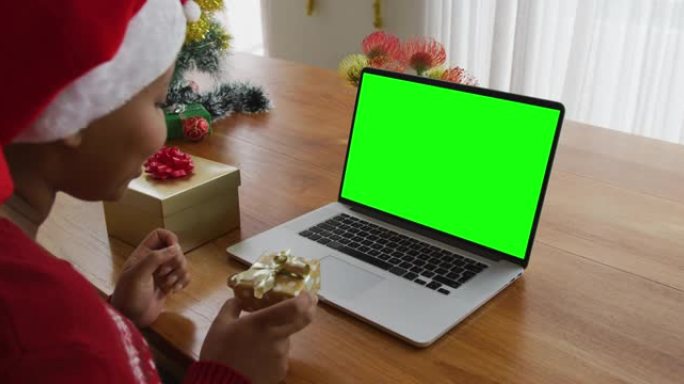 非洲裔美国妇女与礼物制作笔记本电脑圣诞视频通话，绿屏复制空间