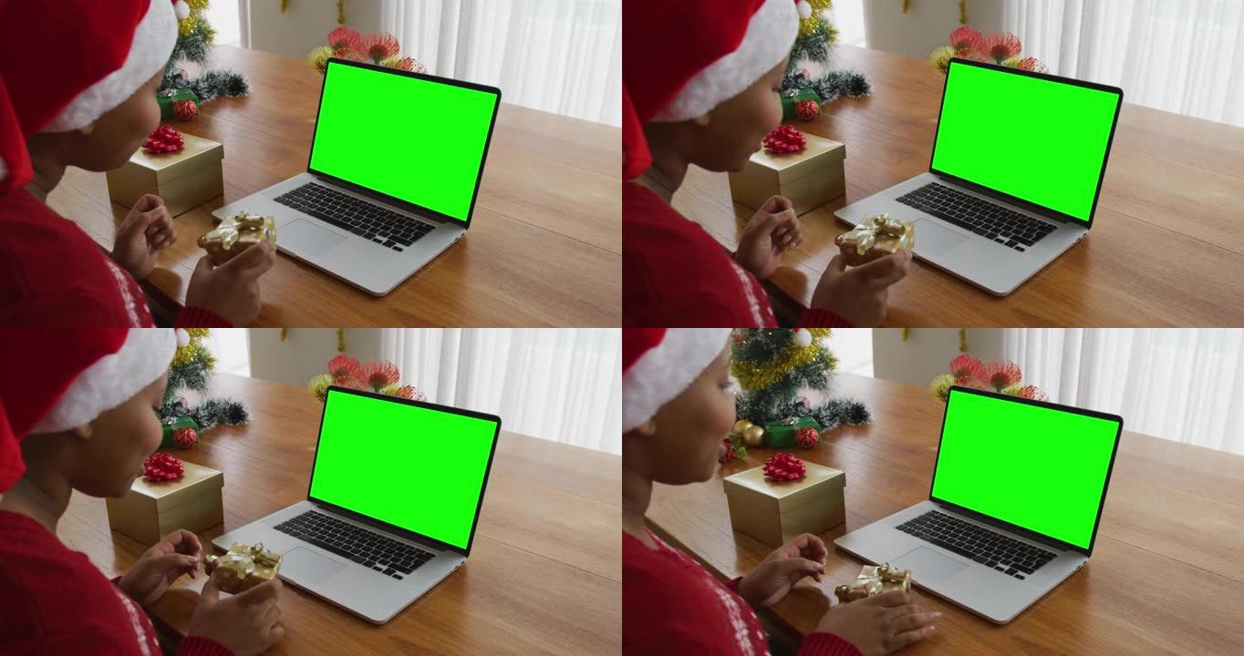 非洲裔美国妇女与礼物制作笔记本电脑圣诞视频通话，绿屏复制空间