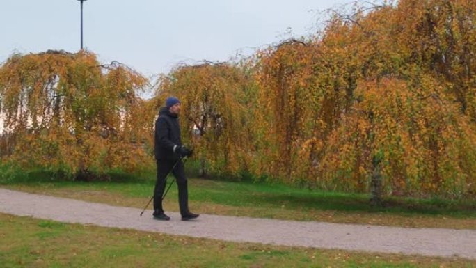 年轻人在北欧步行杆的城市公园中行走