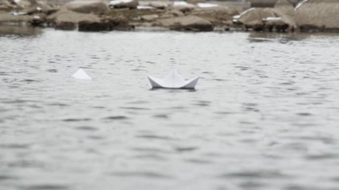 折纸纸船在平静的大海中游泳。舰队创意船手工制作。