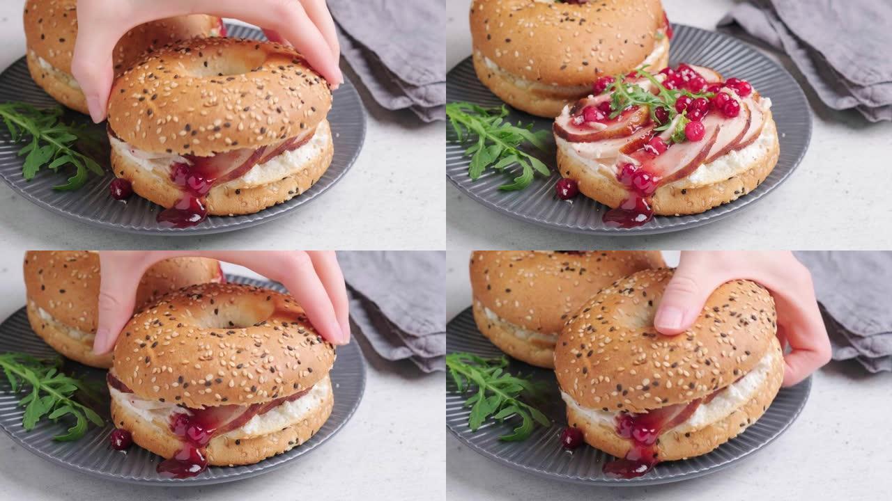 感恩节食品概念。百吉饼三明治配火鸡和蔓越莓酱，放在灰色盘子上。