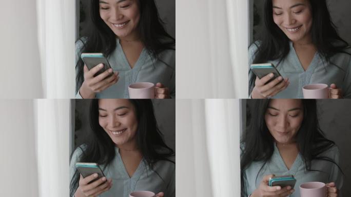 年轻的亚洲妇女发短信给朋友，透过窗户看，享受咖啡