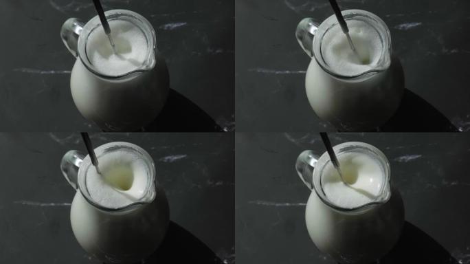 用起泡剂在杯子里打牛奶。牛奶手动搅拌器。用起泡剂制作泡沫牛奶。为咖啡准备牛奶。一步一步