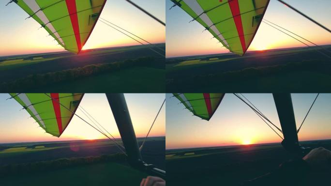 日落时机动悬挂式滑翔机在野外飞行