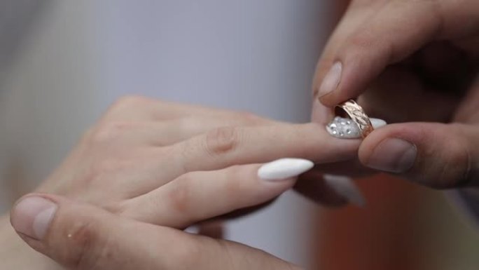 新郎戴上新娘的结婚戒指，一个紧密的计划
