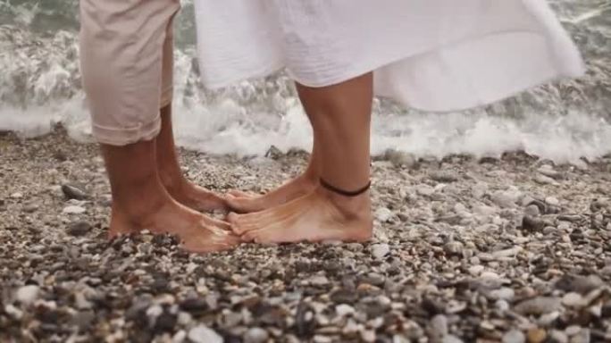 高加索夫妇愉快地站在海边泡脚