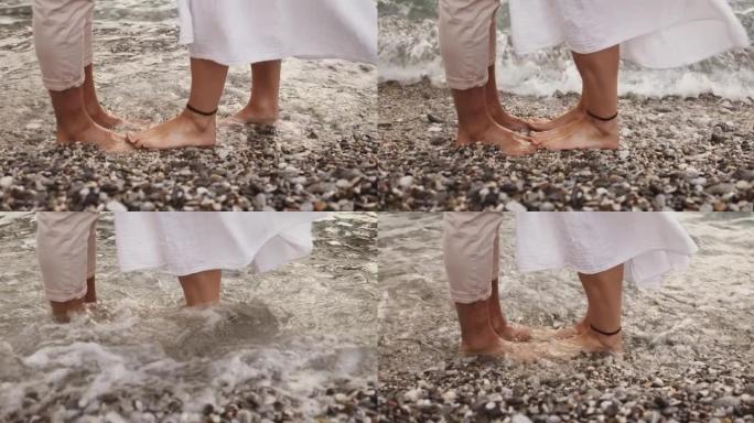 高加索夫妇愉快地站在海边泡脚