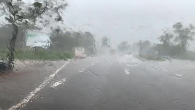 天气和交通在路上在大雨中，前挡风玻璃雨刷一直在工作
