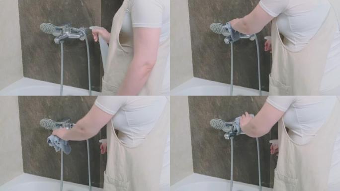 男人用抹布擦拭水槽水龙头来打扫浴室。洗手间里戴着黄色橡胶手套的消毒