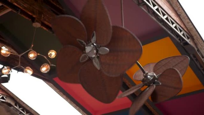 天花板上悬挂的两个棕色大风扇为大厅降温