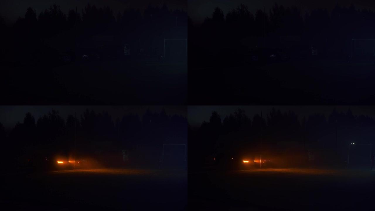 汽车前灯在黑暗的外面发出橙色的光。闪烁的报警灯。电影概念