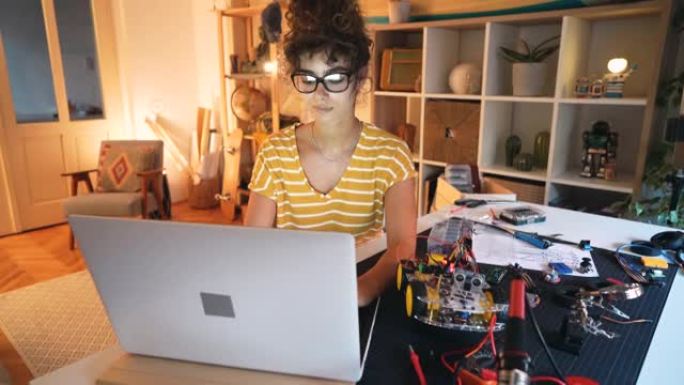 沉思的女程序员，试图在她的代码程序中找到解决方案，以解决她为机器人工程竞赛制作的机器人汽车原型