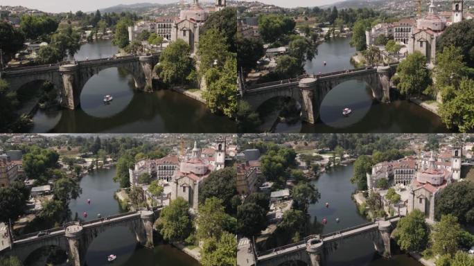 在葡萄牙阿马兰特镇的历史城堡桥下航行的天鹅船。空中上升视图