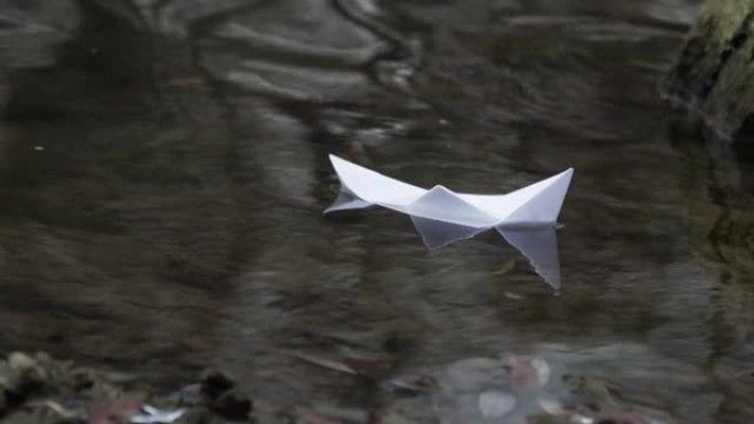 折纸船在平静的湖里游泳。漂流创意船之旅。