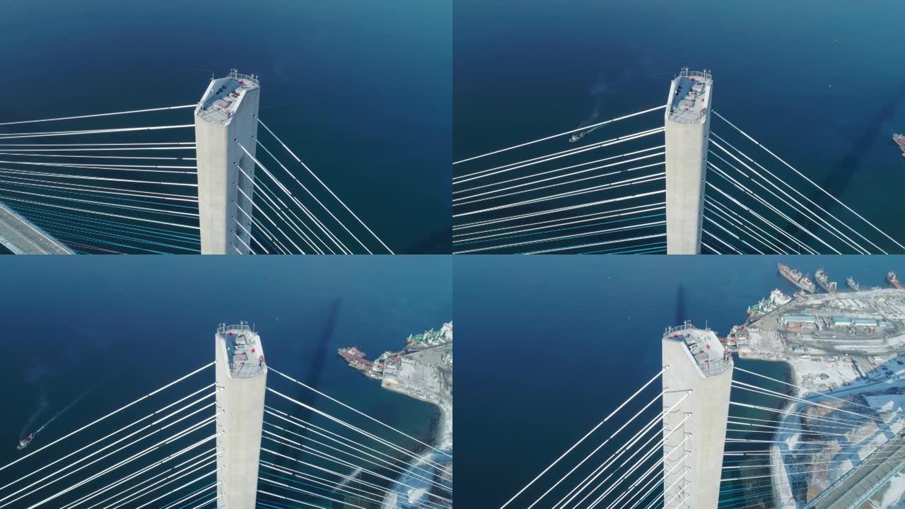 混凝土桥柱的鸟瞰图，上面的工人和工友，电缆被冰覆盖。俄罗斯桥，符拉迪沃斯托克
