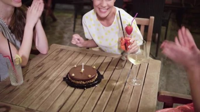 女人在生日蛋糕上吹蜡烛时许愿