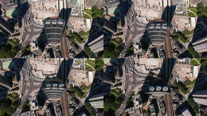 空中鸟瞰现代地层摩天大楼的俯视图，风力涡轮机集成到建筑物中。街道上的交通，通过道路交叉口行驶的车辆。