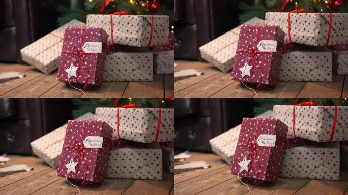 一堆礼物中的圣诞精美礼品盒躺在树下的木地板上。新年礼物，节日和节日购物。圣诞贺卡。特写。慢动作
