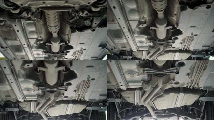 悬吊在液压升降机上的汽车底部视图。汽车修理厂。