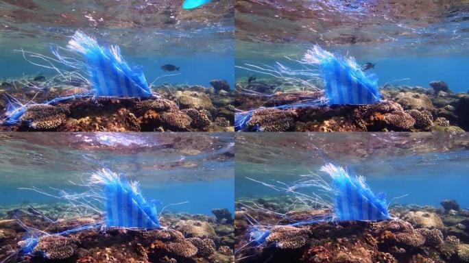 海里的垃圾。海洋的塑料污染。用过的蓝色塑料袋在阳光下慢慢漂流在水下。背光。塑料垃圾环境污染问题
