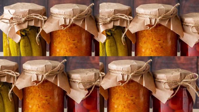 木制背景上的发酵蔬菜罐子。自制黄瓜、西红柿和酸菜罐头。