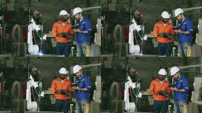 两名工程师在工厂工作控制自动化机器人。