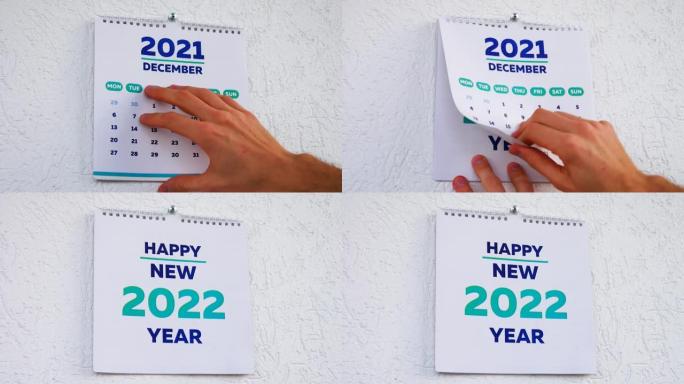 男性手撕下12月页的特写2021年挂历，然后是新2022日历的标题页