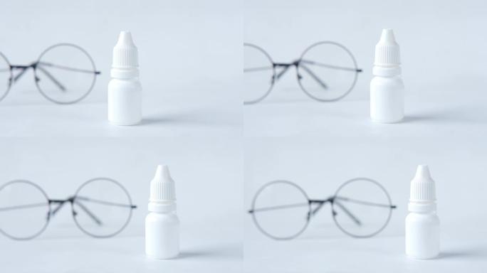 白色滴眼瓶和眼镜的特写，