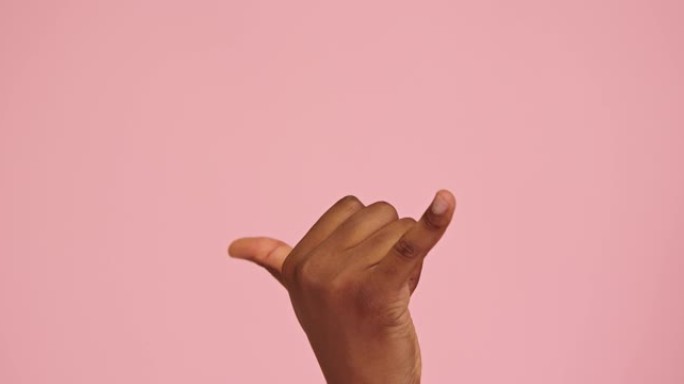 非裔美国人在粉红色背景下孤立的shaka手势