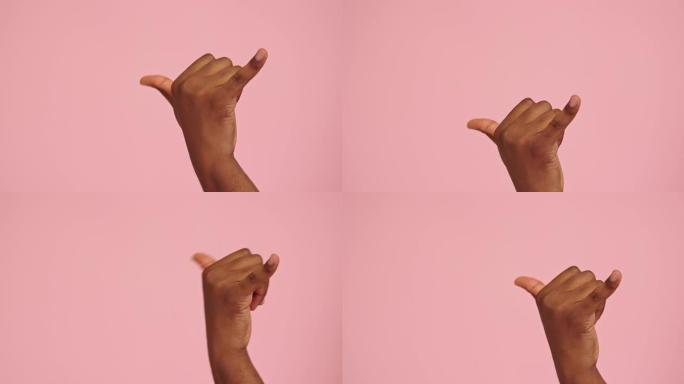 非裔美国人在粉红色背景下孤立的shaka手势
