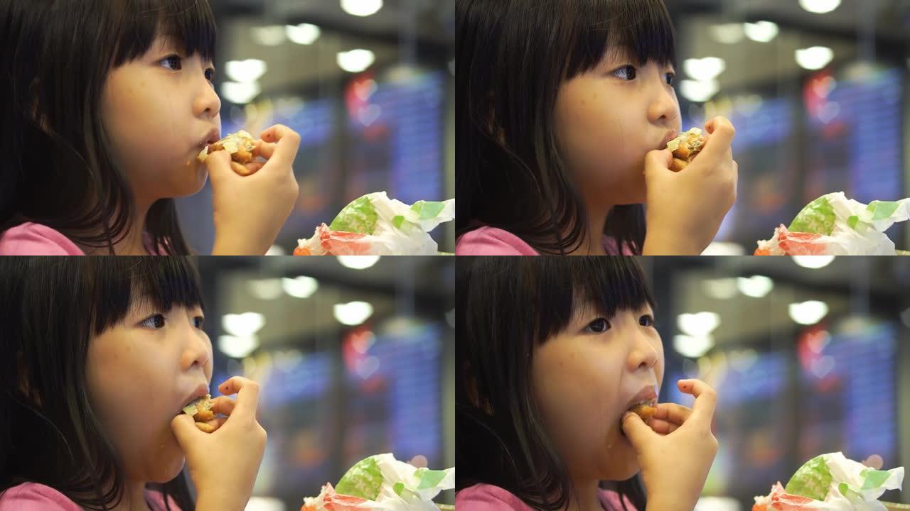 可爱的中国女孩吃汉堡