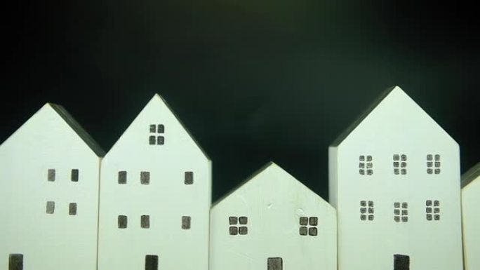 在黑色背景上平移许多木白色房屋的照片