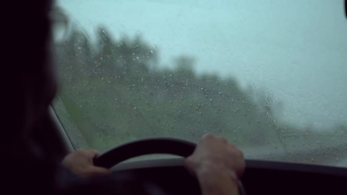 紧急情况下的司机。司机正试图在雨中应付控制。暴风雨。