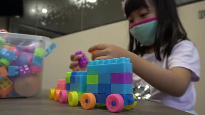 儿童戴口罩组装车与塑料砖玩具。